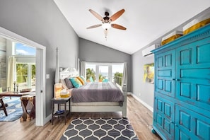 A bedroom with a bed, a ceiling fan, a window, and a blue wardrobe. - Rum Reef, 6 bedroom house in North Side, pool, private beach, kayaks, bikes. (North Side)