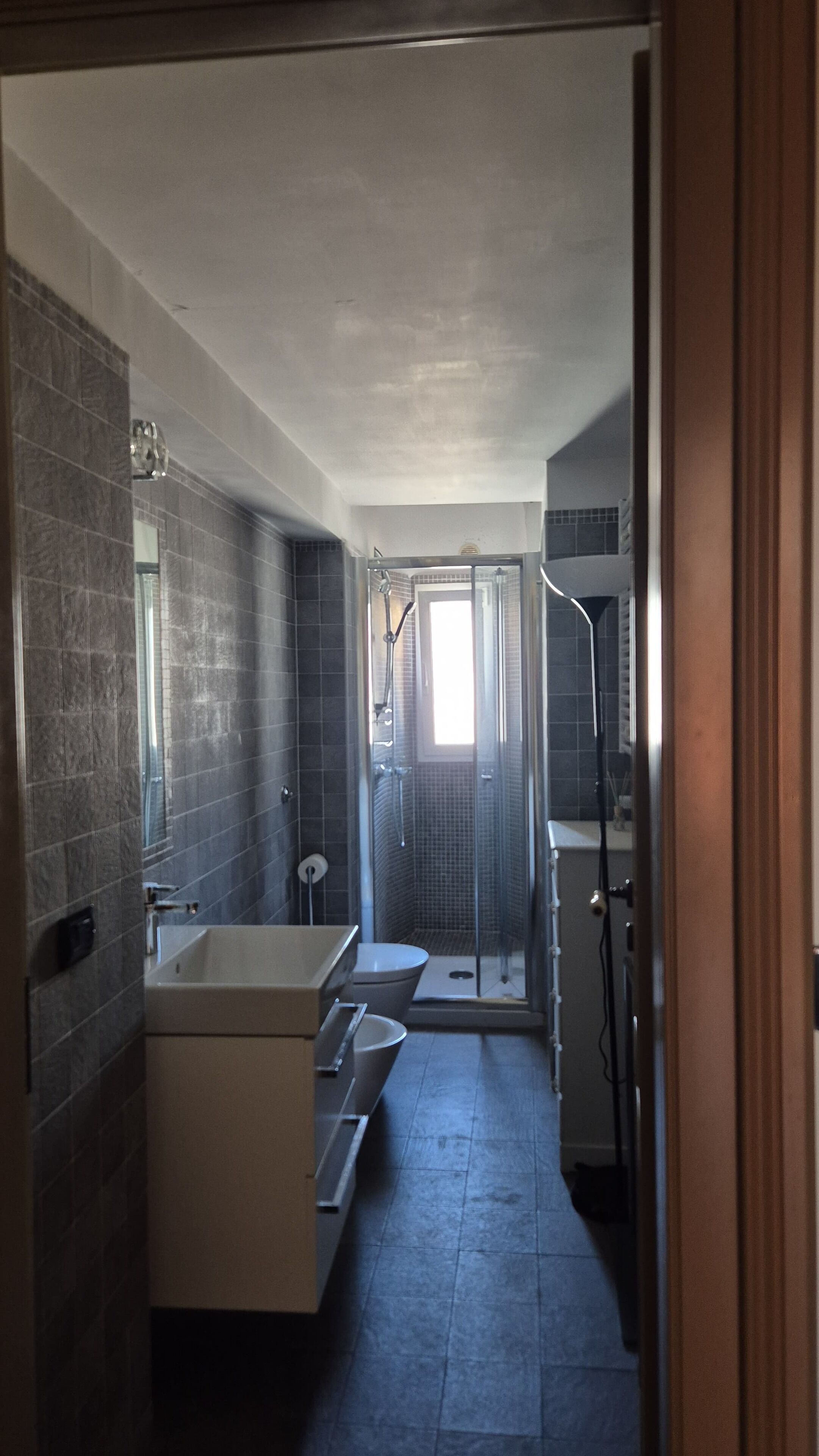 Une petite salle de bain comprenant une douche, des toilettes et un lavabo.