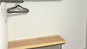 A flat-screen TV mounted on a wall with a wooden bench below.