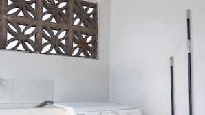 Un espace buanderie comprenant un lave-linge blanc, une serpillière et un panneau décoratif mural.