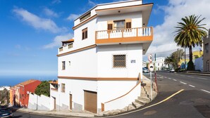 Un bâtiment blanc doté d’un balcon, d’un garage et donnant sur la rue.