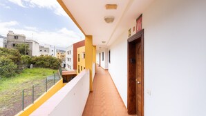 A corridor with a tiled floor, a wooden door, and a yellow wall. - Piso Elegante y Luminoso (La Victoria de Acentejo)