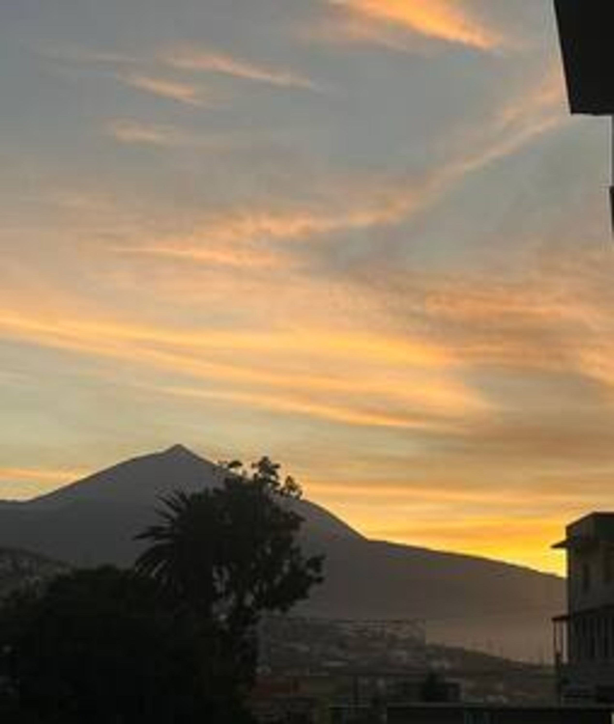 Silhueta de montanha contra um céu de pôr do sol.
