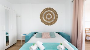 A neatly arranged bedroom with a bed, a small table, and a wardrobe. - Brisa Marina (Tacoronte)