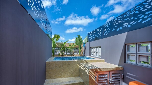 A pool area with steps leading down to the water, surrounded by walls with decorative cutouts and windows. - Luxury Casita Calle 47 Gastronomic Corridor (Mérida)