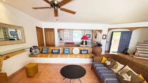 A spacious living area with a sofa set, a round table, and a ceiling fan. - Villa Hereiti by ENJOY VILLAS / 3 bdrm AC /3 bath /private pool and front lagoon (PAPETOAI)