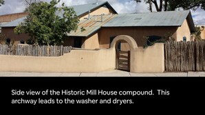 Eine Seitenansicht des Anwesens Historic Mill House mit einem Bogen, der zu Waschmaschine und Trockner führt.