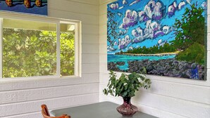 A dining area with a table, chairs, and a painting of a landscape.