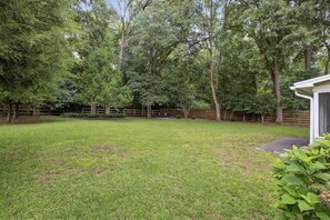 A backyard with a wooden fence, trees, and a shed. - 3BR Retreat w/ Firepit + Big Garden | Washer/Dryer (Tallahassee)