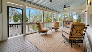 A covered porch with two chairs, a table, ceiling fans, and a view of trees. - Herty House: Walk to UGA & 5 Points (Upper Level) (Athens)