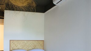 A neatly made bed with white linens in a room with a tiled floor and a ceiling light fixture. - Airport Manini Lodge Studio 5 (Faaa)