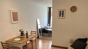 Een knus woongedeelte met een eethoek, een bank en een bed.