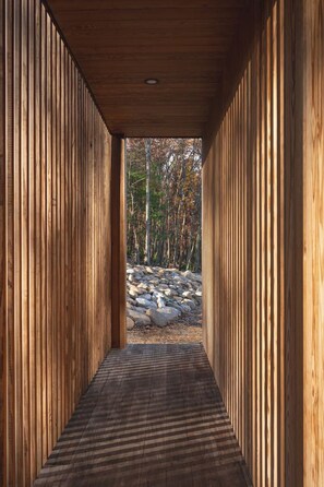 Un corridoio con pareti in legno e vista su una foresta.