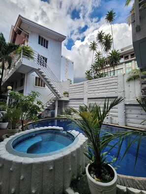 Un hotel con piscina, una scala e palme.