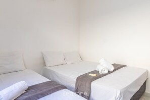Two single beds with white linens and gray blankets, a remote control on the bed, and a towel on the floor. - Apartment With Pool and Barbecue Pdl005 (Porto Seguro)