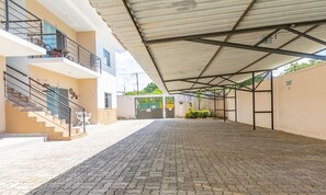 A covered outdoor area with a paved walkway, a staircase, and a gated entrance. - Apartment With Pool and Barbecue Pdl005 (Porto Seguro)