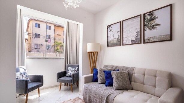 A living room with a sofa, two armchairs, a lamp, and a rug. There are three framed pictures on the wall. - PDC - Apartments in a Condominium With a Pool in Ilheus (Ilhéus)
