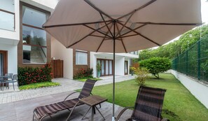 A patio with two wicker chairs and a large umbrella. - House w/ Pool 180m From Beach in Arraial Pbr0003 (Porto Seguro)