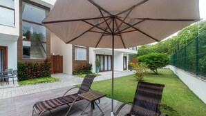 A patio with two wicker chairs and a large umbrella. - House w/ Pool 180m From Beach in Arraial Pbr0003 (Porto Seguro)