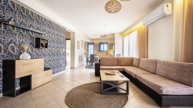 A modern living room with a sectional sofa, a coffee table, and a patterned wall.
