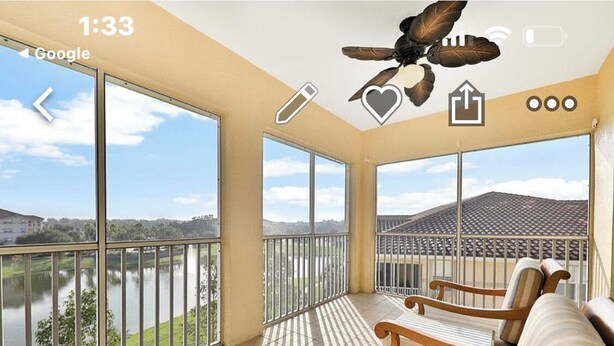 A balcony with a view of a body of water and a building across the street.