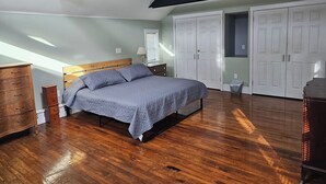 A bedroom with a wooden bed, a dresser, and a walk-in closet. - Discreet 1 Bedroom getaway (Buffalo)