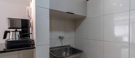 A kitchen with a built-in sink, a coffee maker, and a range hood.