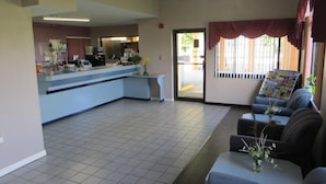 A reception area with a counter, seating, and a view of the outside. - Budget Inn - Orlando Downtown (Orlando)