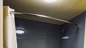 Un baño con bañera, inodoro y ducha.