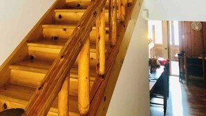 A wooden staircase with a handrail leading to a door.