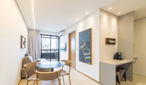 A modern hotel room with a dining area, a coffee station, and artwork on the walls. - Apt With Balcony and Sea View, Maceio Hig1003 (Maceió)