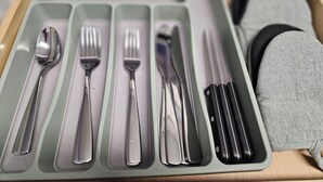 Laatikko, jossa on ruokailuvälineitä, kuten lusikoita, haarukoita ja veitsiä.