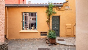 A narrow street with a building featuring a barred window, a door, and a sign reading "PUIRE L'ACCOLBERT LIMPASSE". - Apartment 100m from the beach - historic center (Collioure)