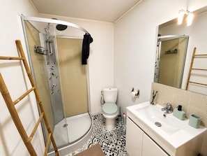 A bathroom with a shower, toilet, and sink.