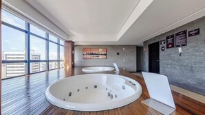 A modern indoor pool area with two hot tubs and a large window providing a view of the city. - Studio w/ Pool 300m From the Beach- Maceio Eti0724 (Maceió)