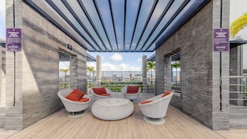 A rooftop patio with wicker furniture and a glass ceiling.