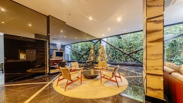 A modern interior with a circular seating area, a large window, and a staircase.