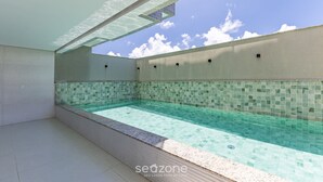 A swimming pool with a tiled edge and a clear blue sky above. - Apartments 450m From the Beach in Ilheus - ERN (Ilhéus)