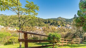 Une clôture en bois offrant une vue sur un village perché sur une colline et une végétation luxuriante.