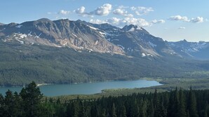 Un paysage de montagne avec un lac et une forêt dense.