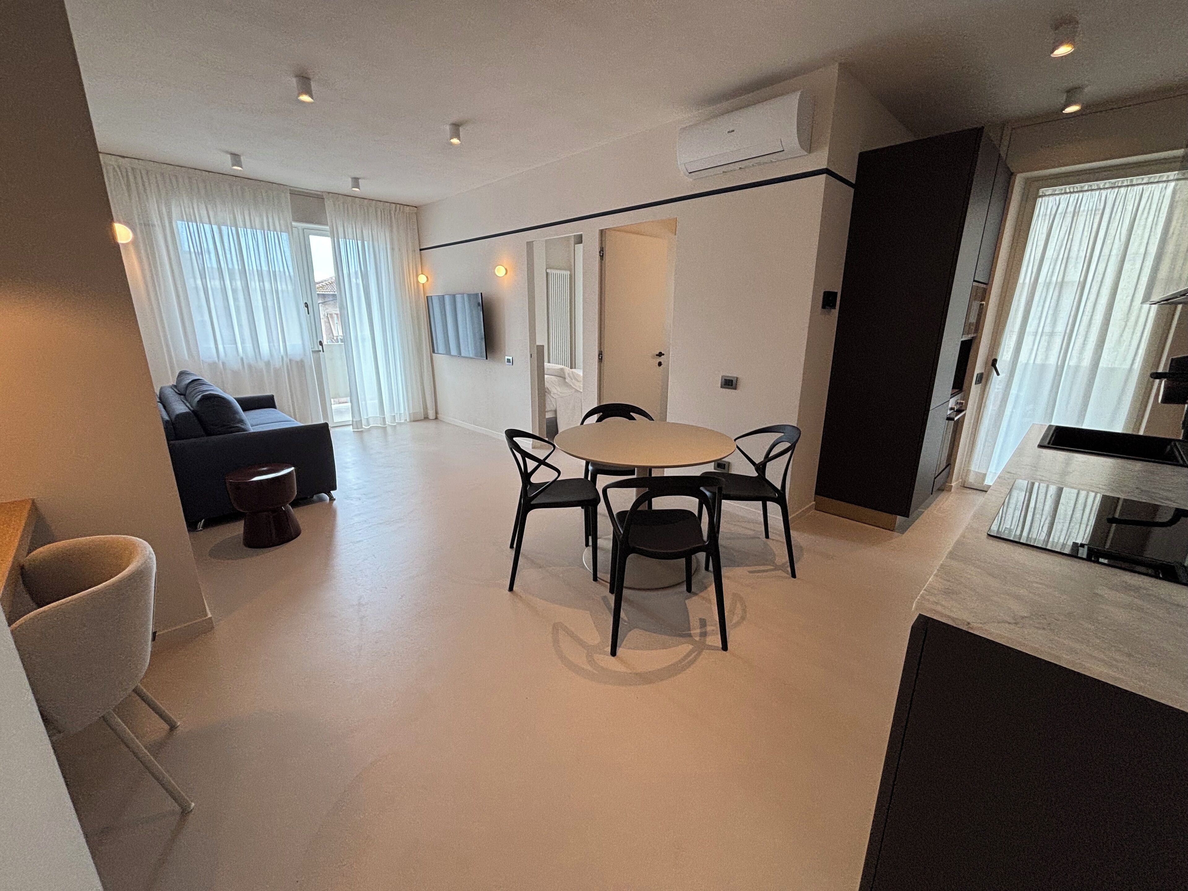 Una sala de estar moderna con un sofá, una mesa de centro y un comedor con sillas.