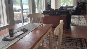 Un salón amplio con zona de comedor, ventanas grandes y ventilador de techo.