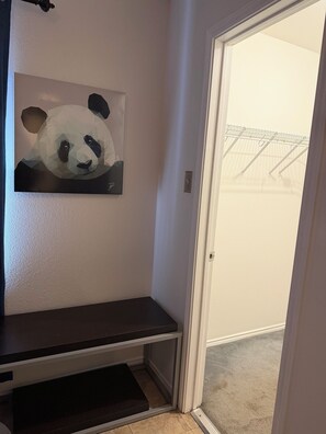 A room with a door leading to a balcony, a wall-mounted shelf, and a doorbell.