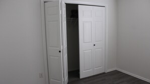 Puerta blanca cerrada en una habitación con suelo de madera oscura.