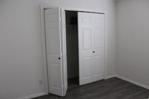 A closed white door in a room with a dark wooden floor. - Spacious 4BR/2BA Near Amazing Restaurants, Alamo, Riverwalk, Missions & Downtown (San Antonio)