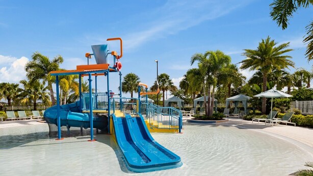 A water park with a blue slide and a water play area.