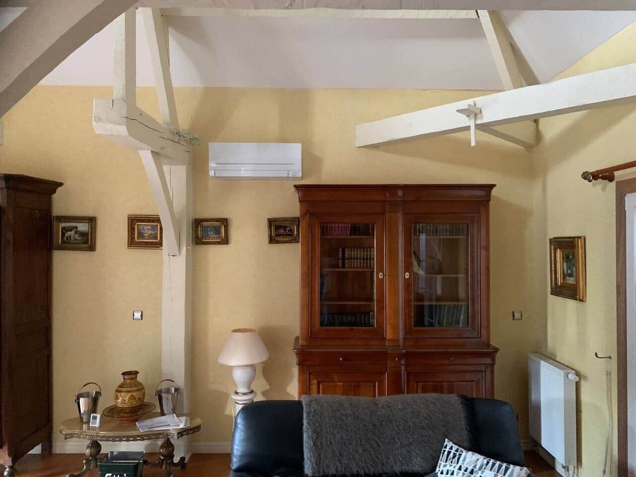 Une pièce avec un meuble en bois, une table avec une lampe et un canapé.