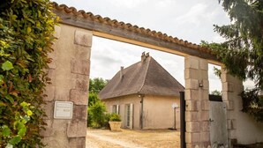 A building with a tiled roof, a door, and a small garden area. - Le Rocal, close to Monbazillac in the shadow of Bergerac (Pomport)