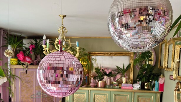 A room with a green cabinet, a pink sofa, a yellow armchair, and a pink armchair. - Bohemian boudoir-style artist apartment. (Royan)