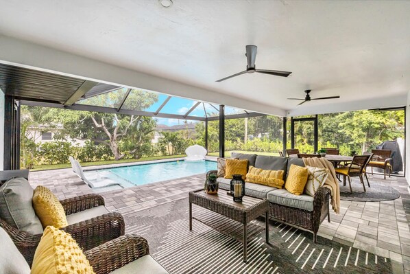 Un área de piscina interior con un sofá, sillas y una mesa de comedor.